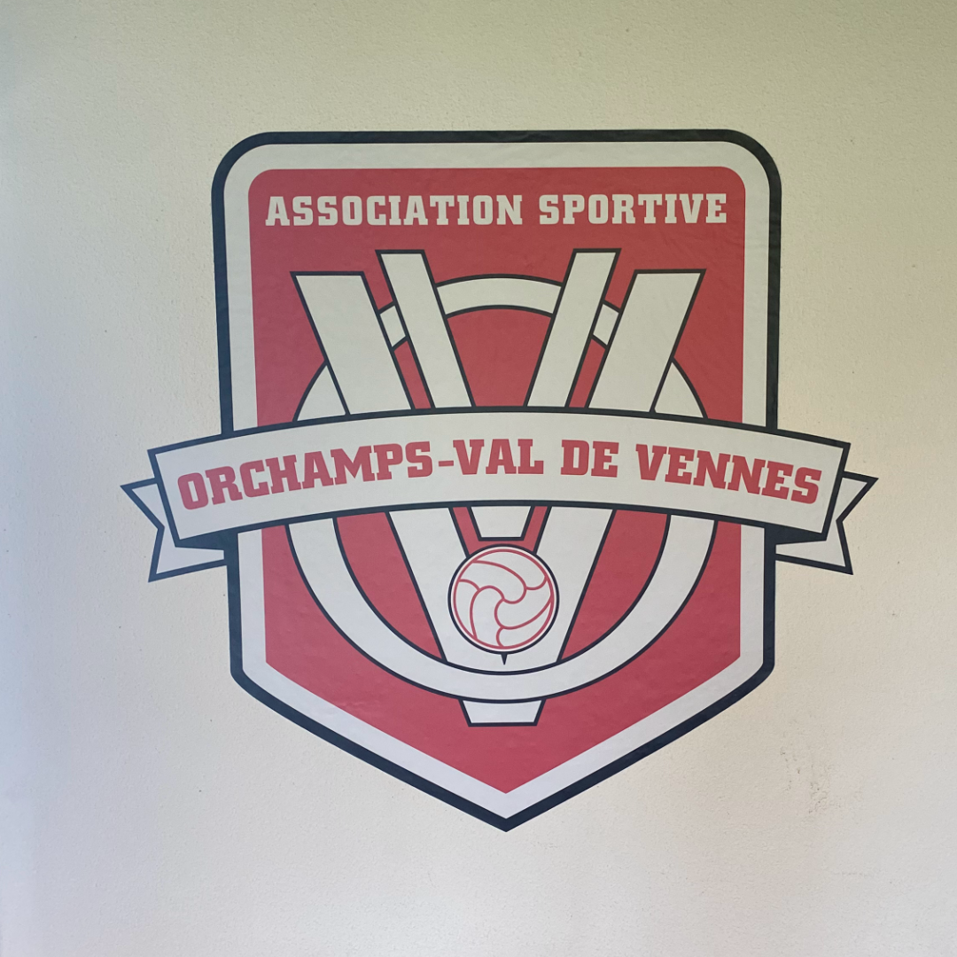 Sticker logo collé sur un mur, créé par l'agence de communication Okami pour l'association sportive Orchamps-Val de Vennes.